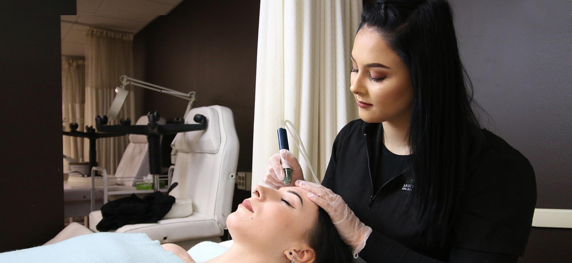 One female Esthetician student applies a skin treatment to another student in the ӣƵ salon spa.