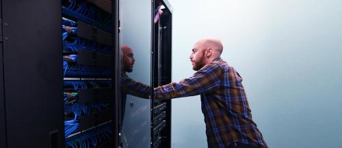 Male computer technician reviews a ӣƵ computer server.